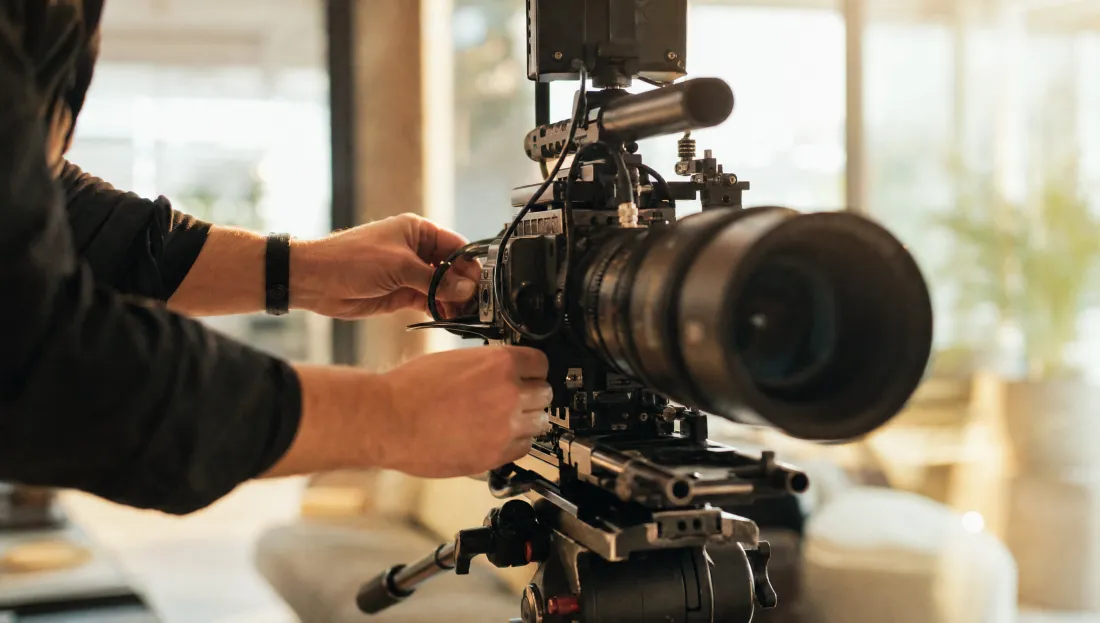 A camera operator rigging a cinema camera on set